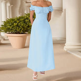 Woman wearing a light blue off-shoulder dress standing in front of classical columns.